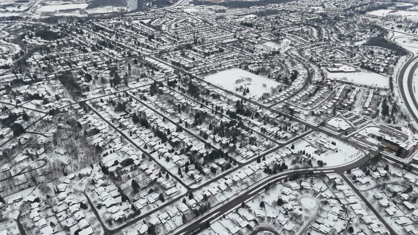 A breathtaking drone view of the snow covering all the roads, parks and buildings of Kitchener city during winter in Ontario, Canada