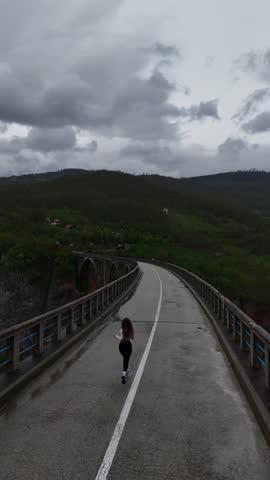 Drone View of Woman Running on Bridge Over Tara River.Dzhurdzhevich Bridge.Montenegro