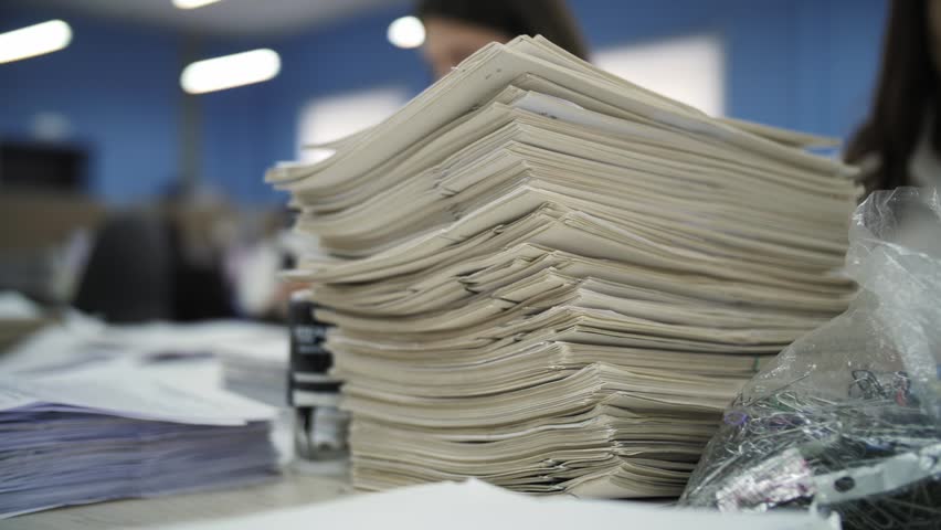 Large stack of documents on desk
