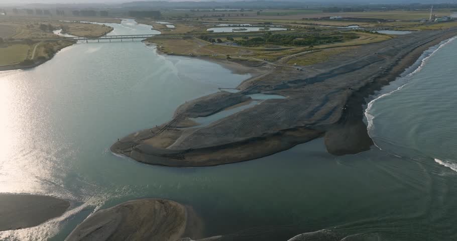 Aerial view of river meeting ocean, exposed sandbar. People on the shore. Tide change. Waitangi Regional Park, Napier, Hawkes Bay, New Zealand