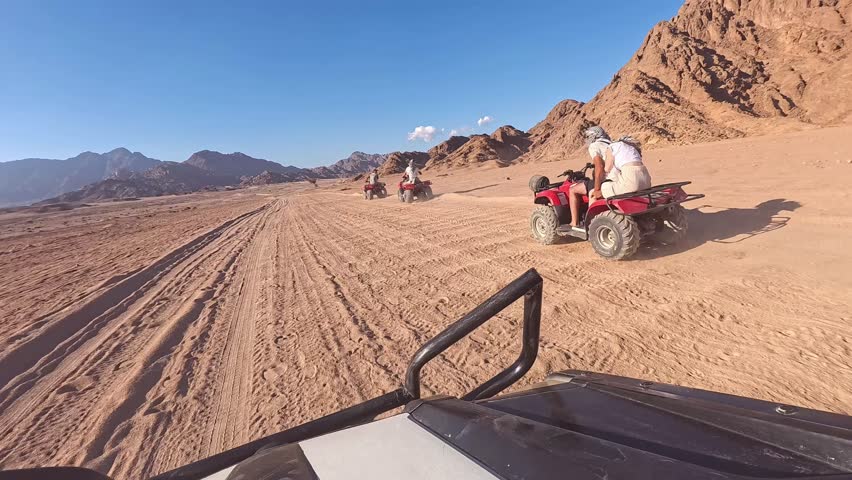Quad bike ride through the desert near Sharm el Sheikh, Egypt.Adventures of desert off-road on ATV.Sand and Sand Borkhan. Rock and sunset. Quad Cycle Travel. Excursion with people.