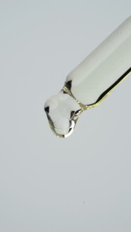 Closeup shot showcasing a pipette dropping essential facial oil, serum or liquid