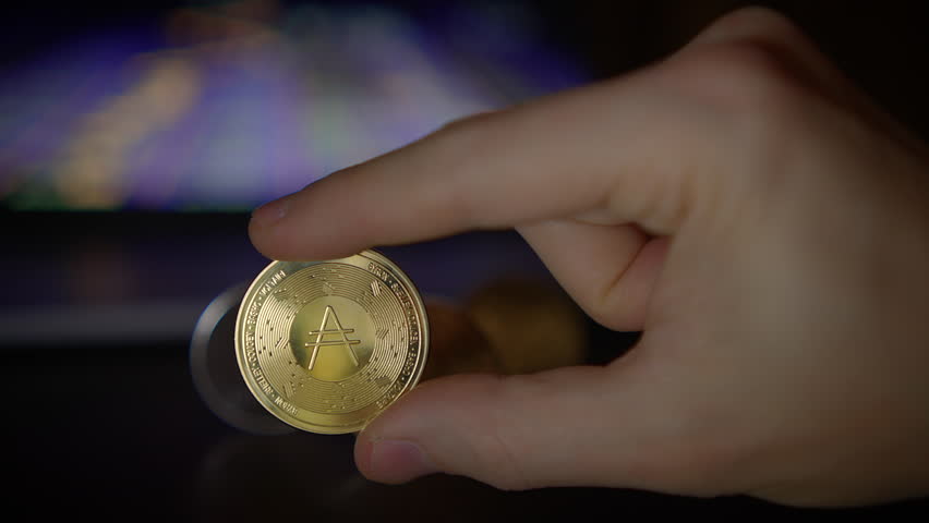 The image showcases various Cryptocurrency Coins artfully placed on a dark and moody surface