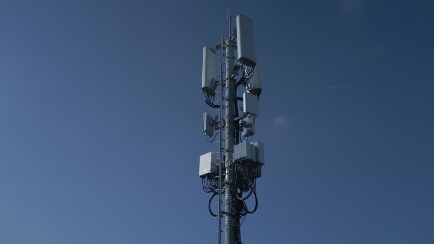 A telecom tower stands against a clear blue sky, showcasing its importance in communication