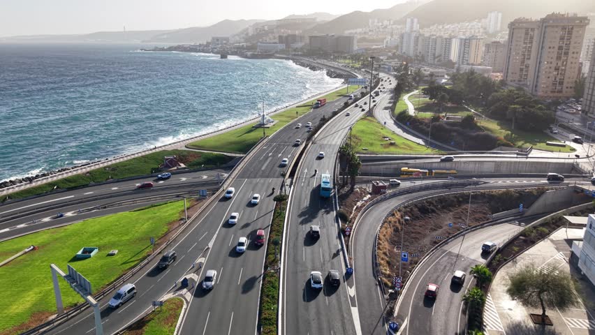 Coastal road view in Las Palmas de Gran Canaria during a sunny day with cars and ocean in sight