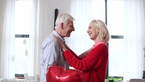 elderly couple in love celebrates Valentine's Day at home and kisses, old man talks and flirts with his wife, retired people in love - Powered by Shutterstock - Get 15% off with code: PIKWIZARD15