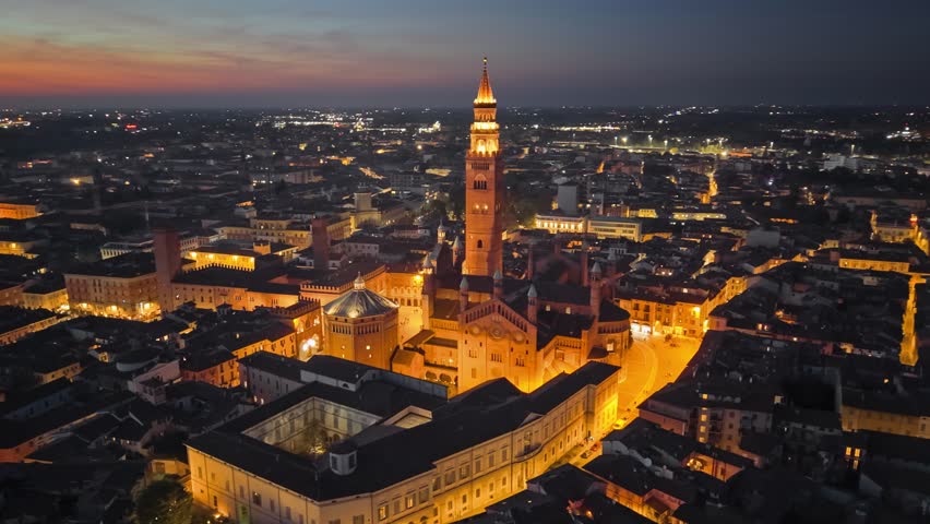 Evening after sunset aerial view of Cremona, Lombardy, Italy. Stunning nighttime view of Cremona showcasing illuminated architecture and city landscape at dusk