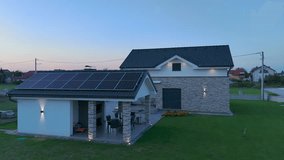 Exterior of modern house with solar panels and fancy light design at dusk. Aerial - Powered by Shutterstock - Get 15% off with code: PIKWIZARD15