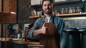 Satisfied Caucasian barista man guy small business owner showing thumb up hand success gesture in coffee shop cafeteria happy waiter recommending smiling male adult worker like approve cafe catering - Powered by Shutterstock - Get 15% off with code: PIKWIZARD15