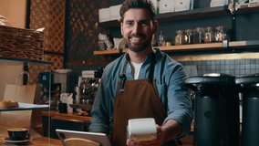 Carefree Caucasian guy entrepreneur owner worker make order client payment buy device tablet in coffee shop small business barista smile delivery cafeteria adult man waiter working in cafe restaurant - Powered by Shutterstock - Get 15% off with code: PIKWIZARD15