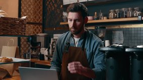 Pensive Caucasian staff employee restaurant worker barista guy using laptop ordering products online shopping in Internet male small business owner thinking in cafeteria waiter man type computer cafe - Powered by Shutterstock - Get 15% off with code: PIKWIZARD15