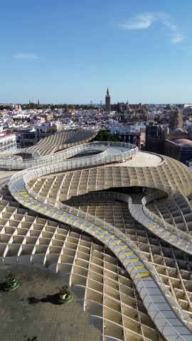 Aerial drone footage of Seville, Spain, showcasing the iconic Metropol Parasol and the breathtaking cityscape with the Giralda and Seville Cathedral. Stunning urban scenery from above!