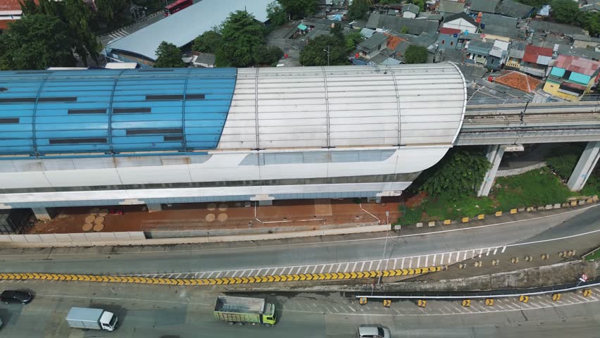 Aerial footage of a Jakarta LRT station, showing the station building, tracks, and surrounding area.