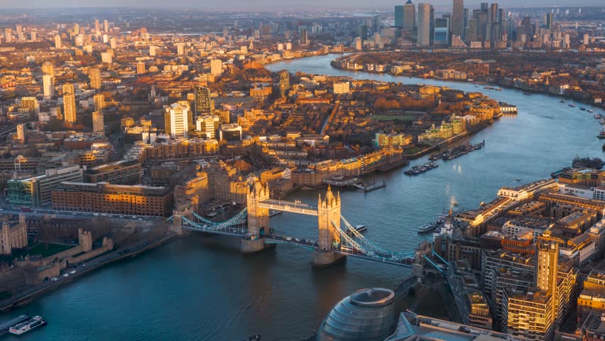 Beautiful sunset time lapse view of Tower Bridge in London with Thames river until back to Canary Wharf, England