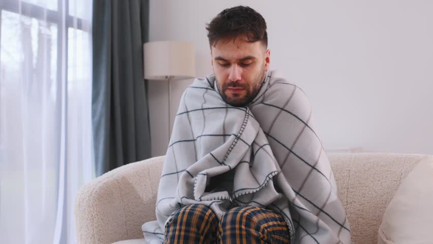 Cup in hand, drinking. Sick man is feeling bad at home.