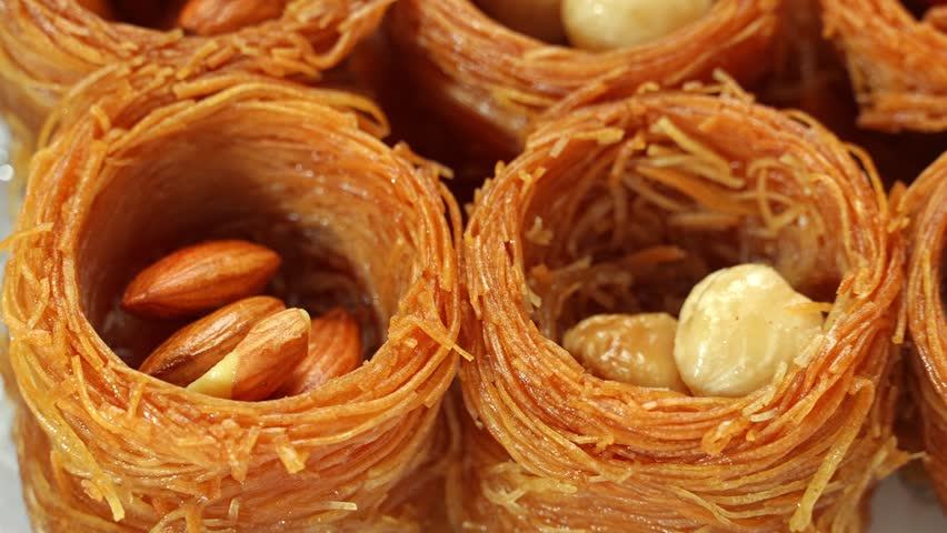 Sweet food Turkish Delight named Kataifi nests or Bird's Nest pastry with almonds and cashew, soaked in sugar syrup
