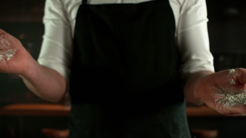 Super Slow Motion Chef Clapping Hands with Flour . Filmed on High Speed Cinema Camera, 1000 fps . Closeup of Bread or Pizza Dough Preparation