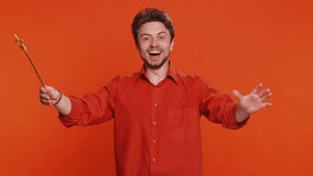 Magician wizard Handsome man gesturing with magic wand fairy stick, making wish come true casting magician spell advertising holidays sale discount. Caucasian bearded guy isolated on orange background - Powered by Shutterstock - Get 15% off with code: PIKWIZARD15