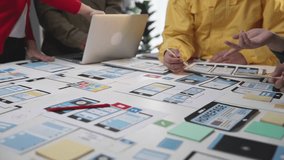 Collaborative Team Meeting for Mobile App Development on Office Table with Digital Prototypes and Laptops. SACTR - Powered by Shutterstock - Get 15% off with code: PIKWIZARD15