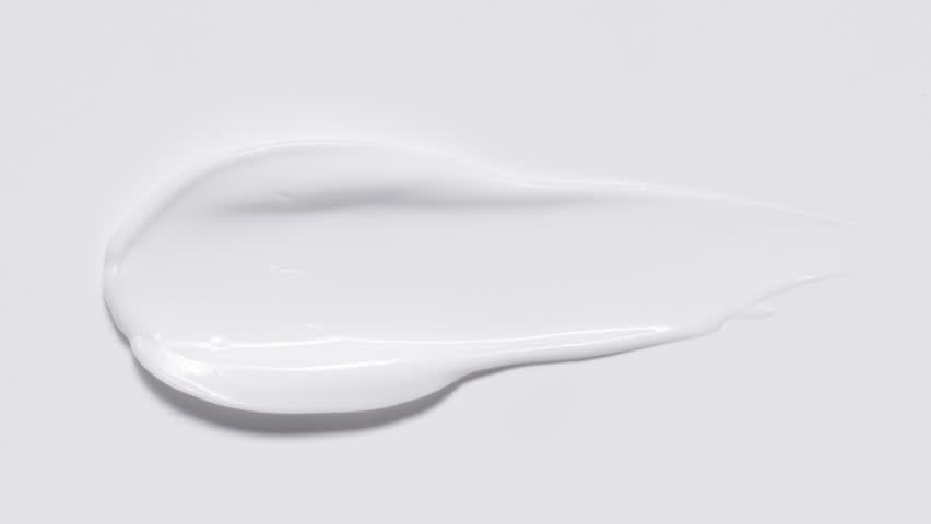 Close up of spatula smear cream texture, texture stroke isolated on white background. Cosmetic product swatch