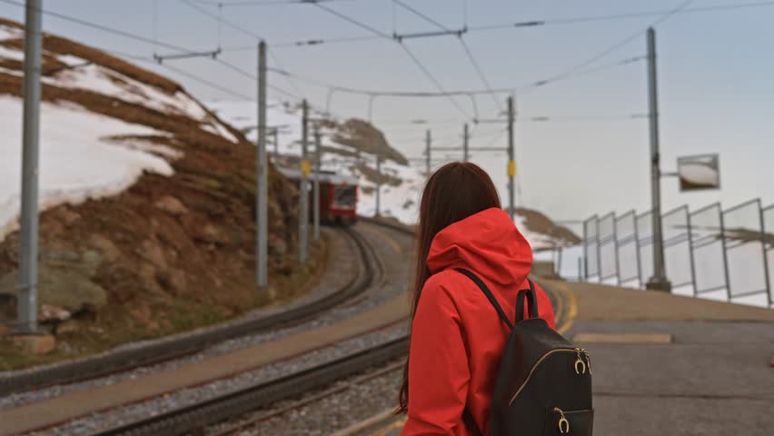 Travel video of  woman waiting in mountain train station as the tran arrives. Tourist female during amazing trip on Gornergrat train