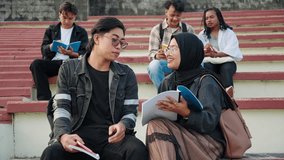 Asian students sitting on college stairway studying together for University exams. Muslim University in Indonesia - Powered by Shutterstock - Get 15% off with code: PIKWIZARD15