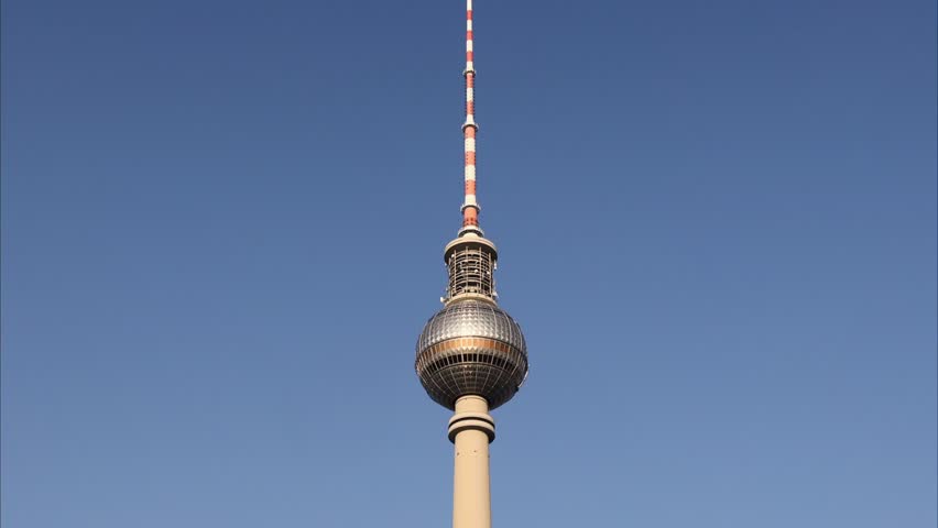 Tracking shot of the Berlin TV tower at Alexanderplatz with blue sky