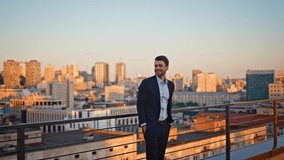 Ambitious entrepreneur standing terrace observing sunset urban view. Confident businessman relaxing on office rooftop enjoying evening cityscape. Determined man corporate leader contemplating skyline. - Powered by Shutterstock - Get 15% off with code: PIKWIZARD15