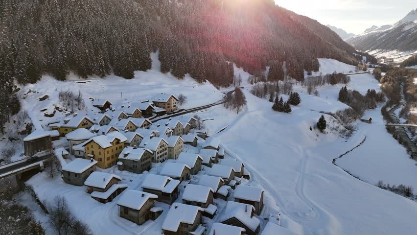 Aerial video above a small snowy village in winter in the Fontana val Bedretto Snow area, Switzerland