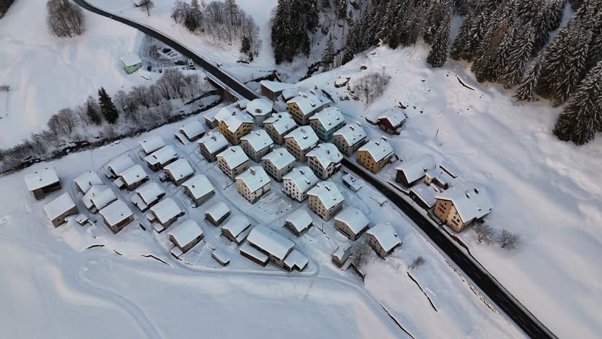 Aerial video above a small snowy village in winter in the Fontana val Bedretto Snow area, Switzerland