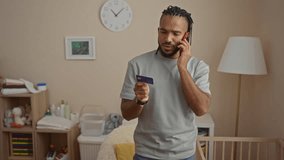 Man talking phone holding credit card living room home indoor adult handsome african american braids apartment casual interior contemplative - Powered by Shutterstock - Get 15% off with code: PIKWIZARD15