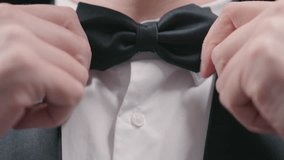 Man Adjusting Black Bow Tie and Tuxedo Shirt. Close Up Shot Formal Event Preparation. Luxury Style - Powered by Shutterstock - Get 15% off with code: PIKWIZARD15