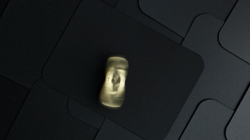 Spinning golden bitcoin coin on a dark surface creates mesmerizing whirl, captivating the viewer's attention in a dynamic motion
