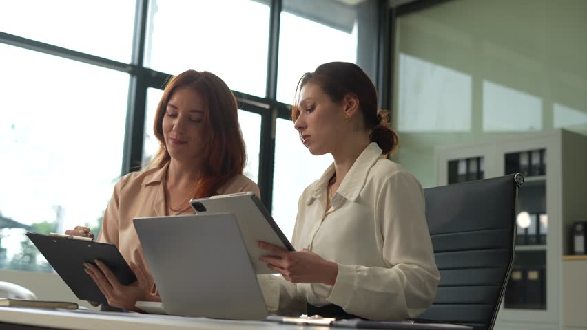 Diverse professionals analyzing documents, graphs, and data with a laptop, tablet, and smartphone. Collaboration, strategy, and success in a modern office. - Powered by Shutterstock - Get 15% off with code: PIKWIZARD15