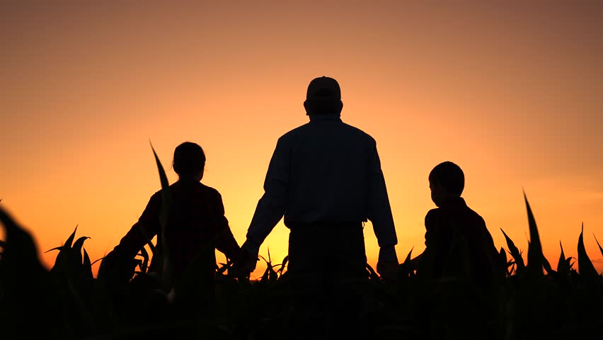 Father farmer children raise hands at sunset in corn field. Happy family, parent son daughter hold hands together, family business teamwork. Dad boy girl raise hands in field sunrise. Family teamwork