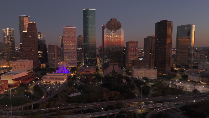 Cinematic aerial shot of Downtown Houston vibrant skyline at dusk, beautifully showcasing stunning architecture, lively city life, and the mesmerizing blend of lights and shadows, Houston, Texas, USA
