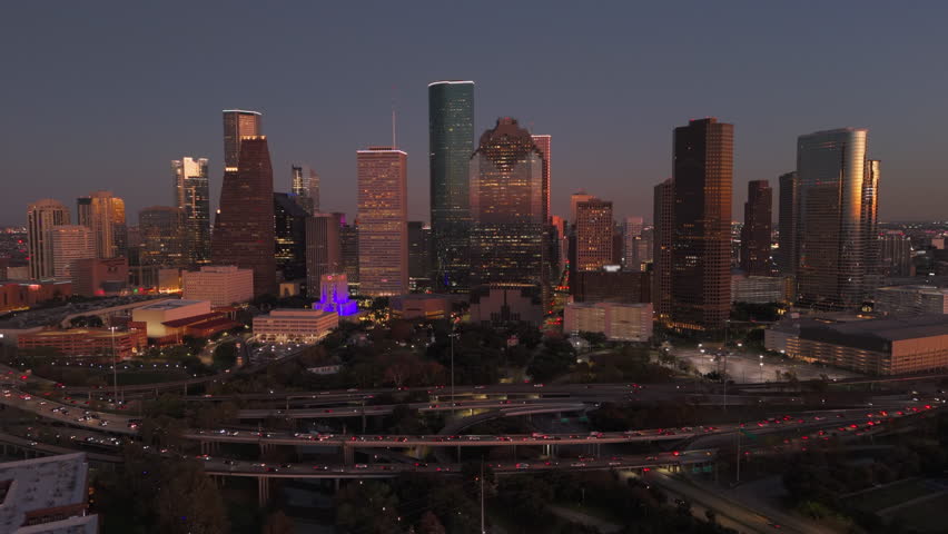 Cinematic aerial shot of Downtown Houston vibrant skyline at dusk, beautifully showcasing stunning architecture, lively city life, and the mesmerizing blend of lights and shadows, Houston, Texas, USA