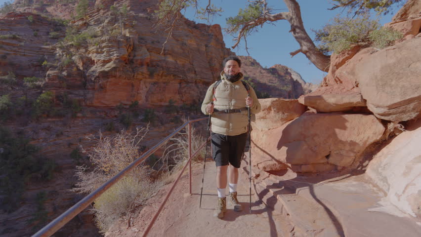 An African American male hiker joyfully explores the breathtaking and stunning trails of Zion National Park, capturing the incredible beauty and splendor of the surrounding nature