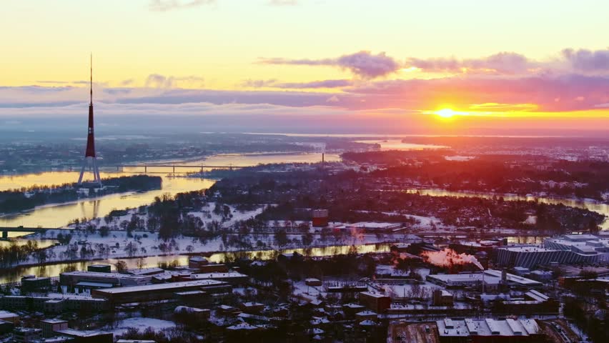 Colorful sunrise of snowy winter Riga, Zaķusala Television Tower, drone, 4K