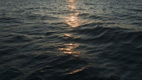 Aerial Video Golden Sunset Reflections on the Calm Ocean with Rippling Water Texture A tranquil and atmospheric ocean scene. - Powered by Shutterstock - Get 15% off with code: PIKWIZARD15