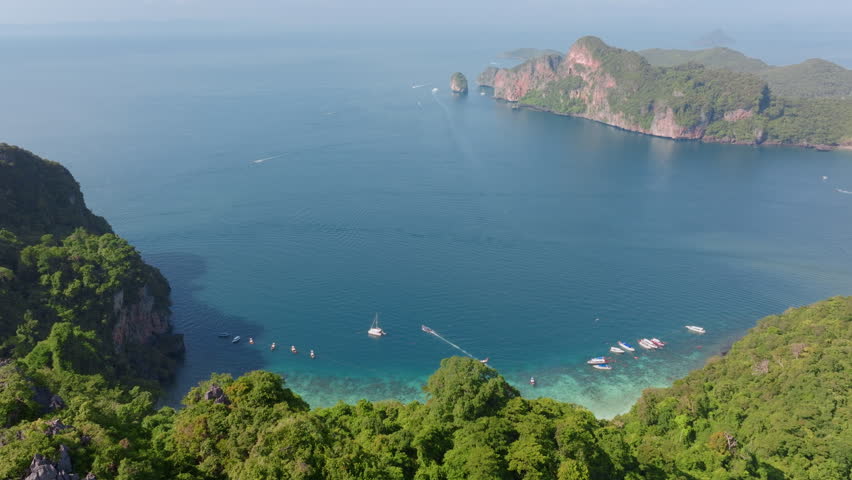 This breathtaking aerial view captures the scenic beauty of Ko Phi Phi Don island in Thailand, showcasing longtail boats below a starlit night sky