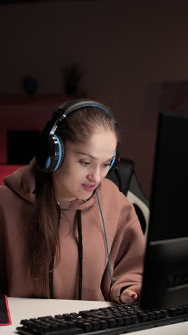 Gaming at home concept. Gamer woman playing online video game using computer streaming and broadcasting. Female player in Online tournament at home interior.