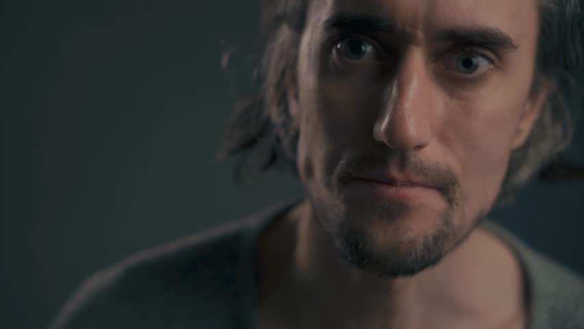 Sad Young European Male Long Hair Emotional close-up of a handsome young European man with big eyes and long hair gazing into the camera with tears