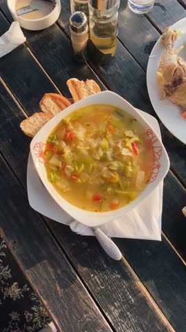 Alfresco dining vertical video. Camera pans over table of food, top down shot, sunlight cast on table during sunset outdoors. Travel dining concept. Authentic local food of Cuba.