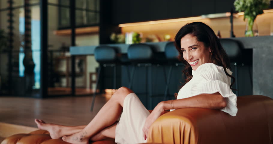 Mature woman, face and relax in modern home, early retirement and comfortable on luxury couch. Peace, portrait and happy person chilling in living room, laughing and funny humor on weekend sofa