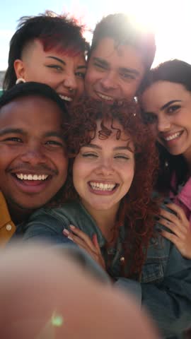 Cheerful multi ethnic friends capturing playful moments, creating candid selfie memories with funny faces, blowing kisses, and enjoying vibrant sunny day together
