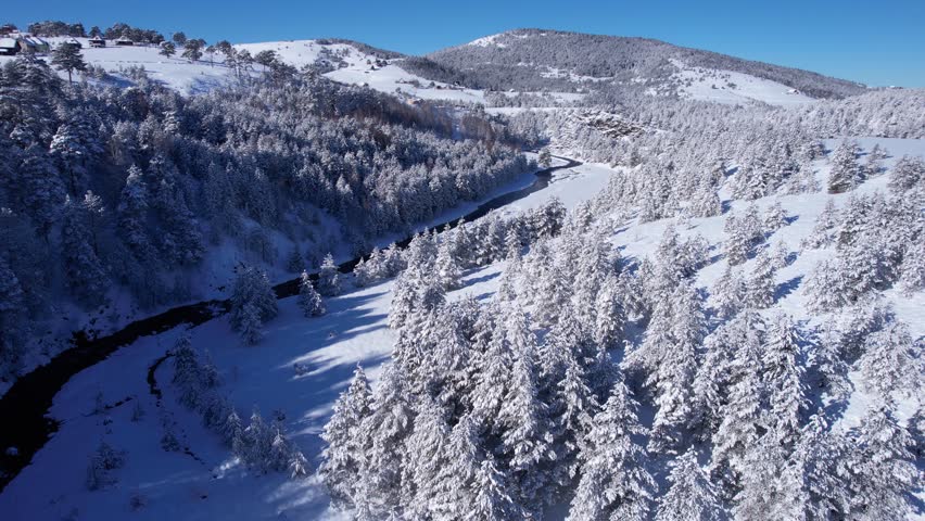 Aerial View of Snow Capped Hills, Forest and River on Sunny Winter Day in Mountains