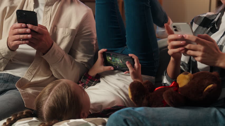 Family mother father daughter girl kid child parents man woman using mobile phones smartphones gadgets addict problem ignoring each other video game shopping evening home addiction dependency overuse