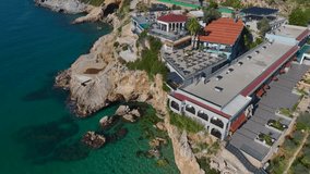 Aerial Video: Cliffside Restaurants Overlooking the Mediterranean Sea With Infinity Pools and a Sandy Beach A unique coastal experience captured dynamically. - Powered by Shutterstock - Get 15% off with code: PIKWIZARD15