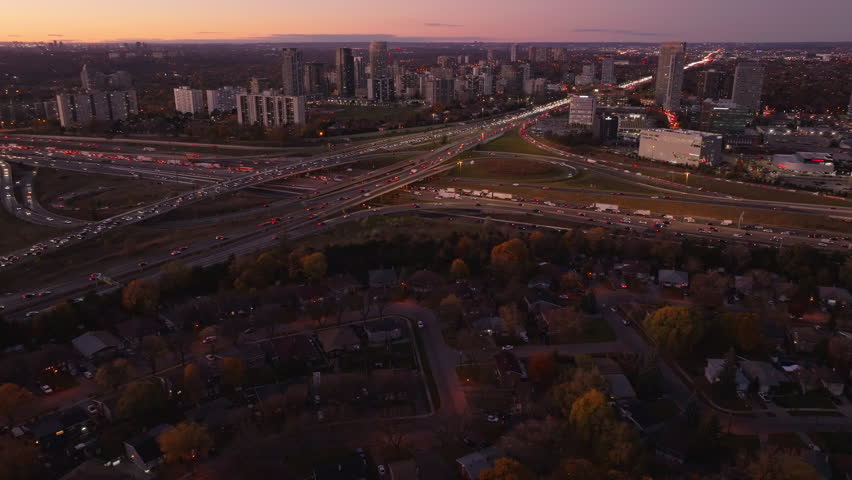 Ontario’s 401 and 404 highways at dusk with city lights and traffic, aerial view
